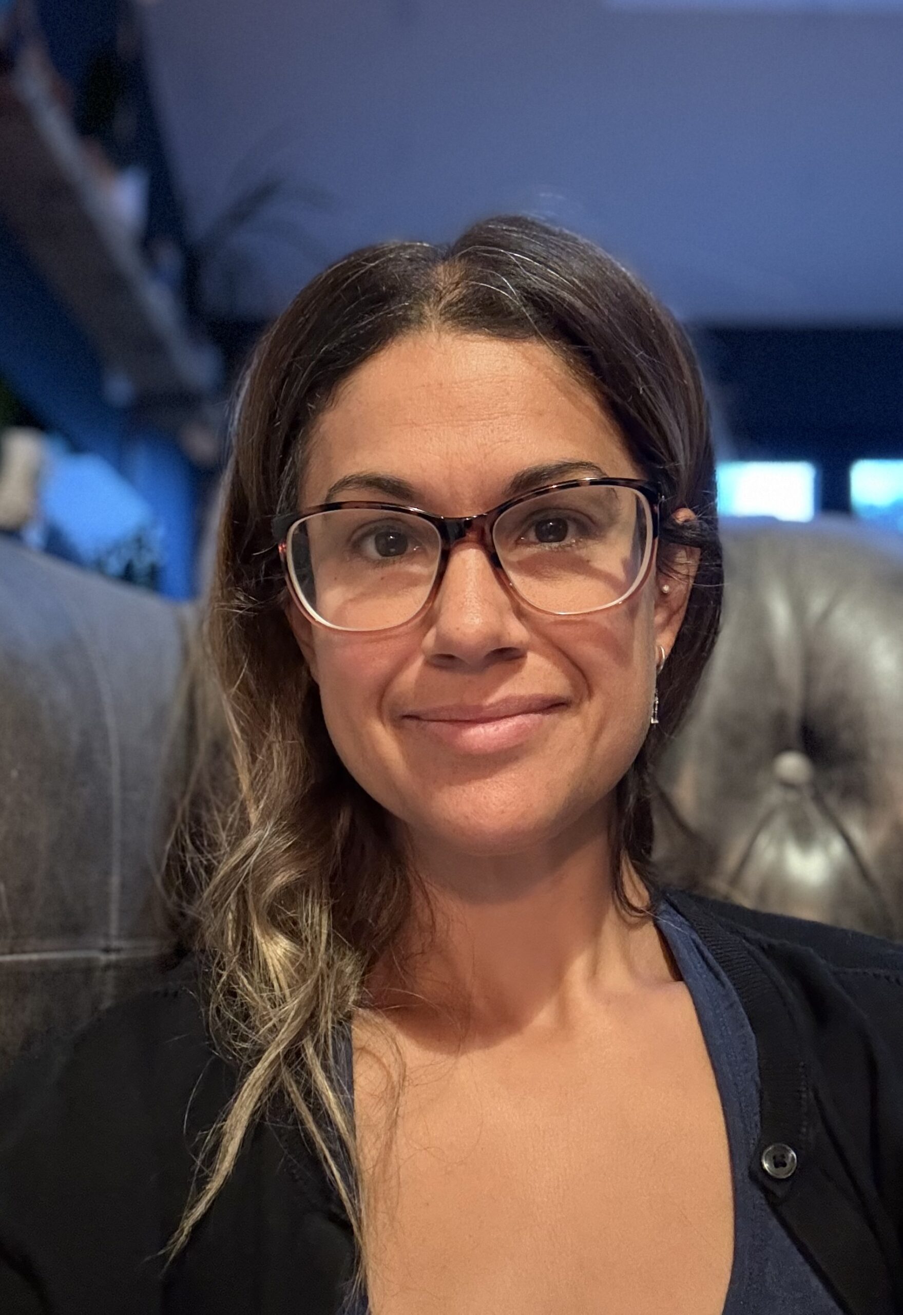 Portrait picture of Female with glasses sat in armchair in home environment