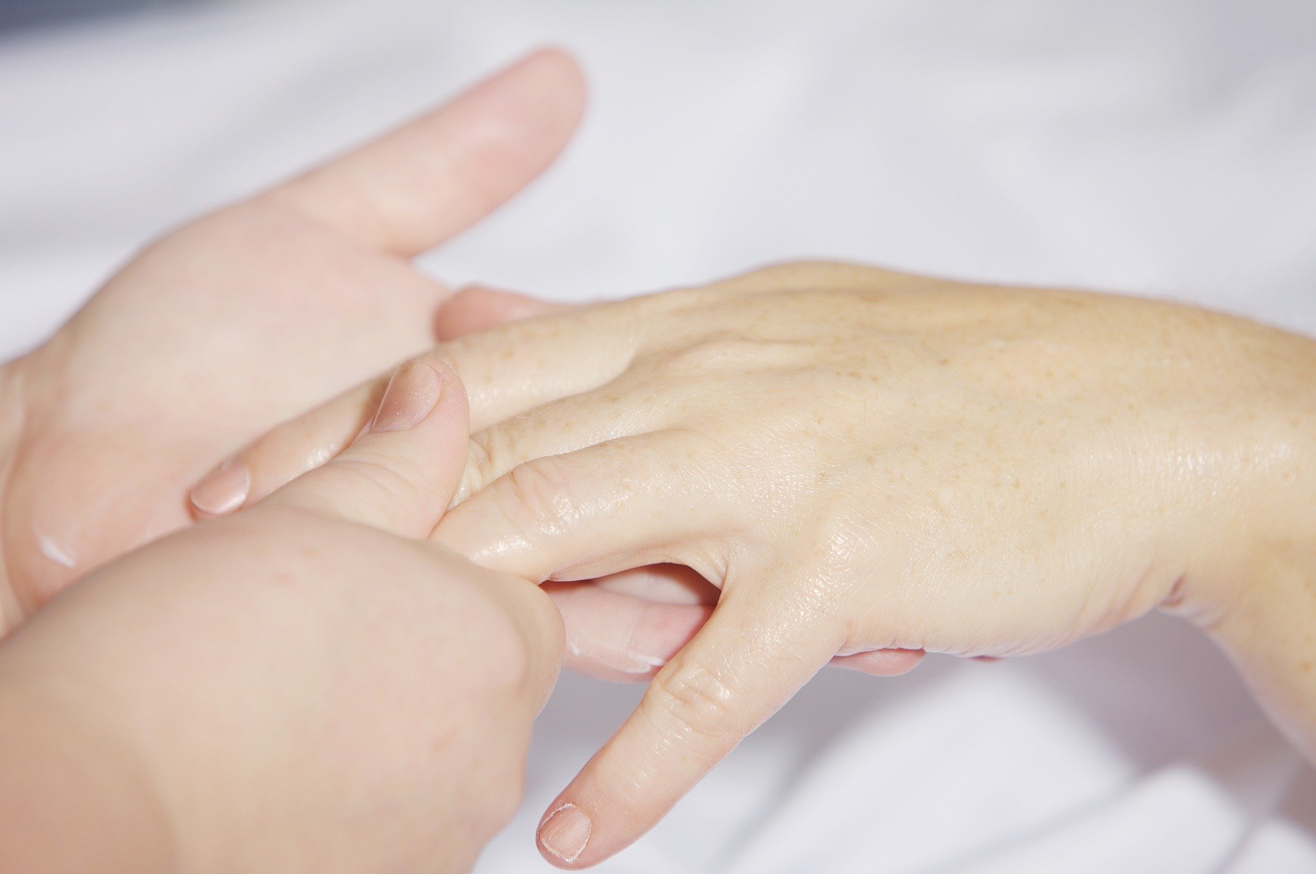 Two hands- one hand receiving therapeutic massage from another